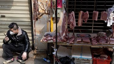 Un vendedor espera&nbsp;a clientes en un estante cerca de un mercado aún parcialmente cerrado por el brote de coronavirus en Wuhan, en el centro de China.&nbsp;