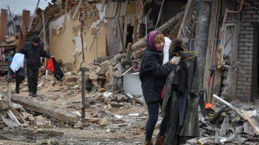 Habitantes locales cargan sus pertenencias al salir de sus casas en Zaporiyia, Ucrania, el domingo 1 de enero de 2023.
