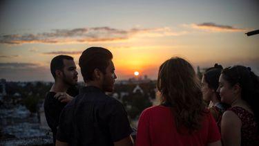 Marcos Marzo, segundo desde la izquierda, habla con sus amigos que vinieron a despedirse de él luego de recibir la noticia de que obtuvo un permiso para viajar a Estados Unidos, en La Habana, Cuba.