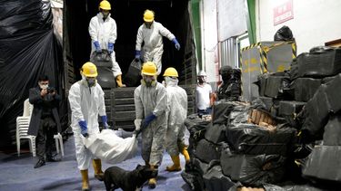 Trabajadores cargan cocaína incautada en varios operativos de la policía para su incineración en Cayambe, Ecuador.