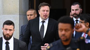 El multimillonario Elon Musk custodiado por su equipo de seguridad.