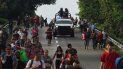 Miembros de la Guardia Nacional avanzan junto a migrantes por la carretera hacia la salida a Huixtla, estado de Chiapas, México, la madrugada del jueves 9 de junio de 2022. 