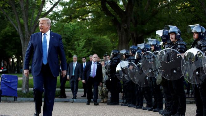 El presidente Donald Trump camina el lunes 1 de junio de 2020 junto a agentes policiales en el parque Lafayette frente a la Casa Blanca, en Washington.&nbsp;