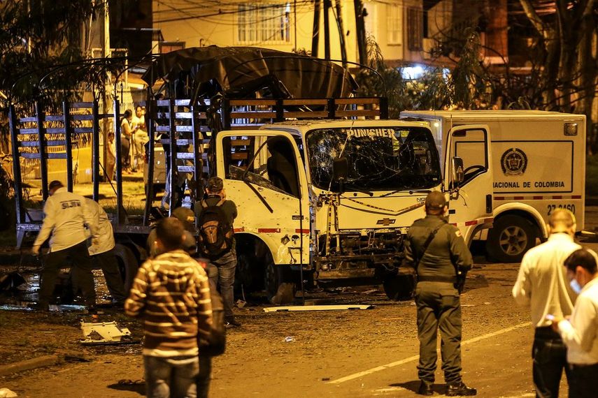 Agentes de seguridad inspeccionan un camión de la policía nacional destruido por un artefacto explosivo en Cali, Colombia, el 8 de enero de 2022, un atentado que se tribuyó el grupo terrorista ELN.&nbsp;