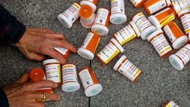 Una persona recoge del suelo envases de medicamentos.&nbsp;