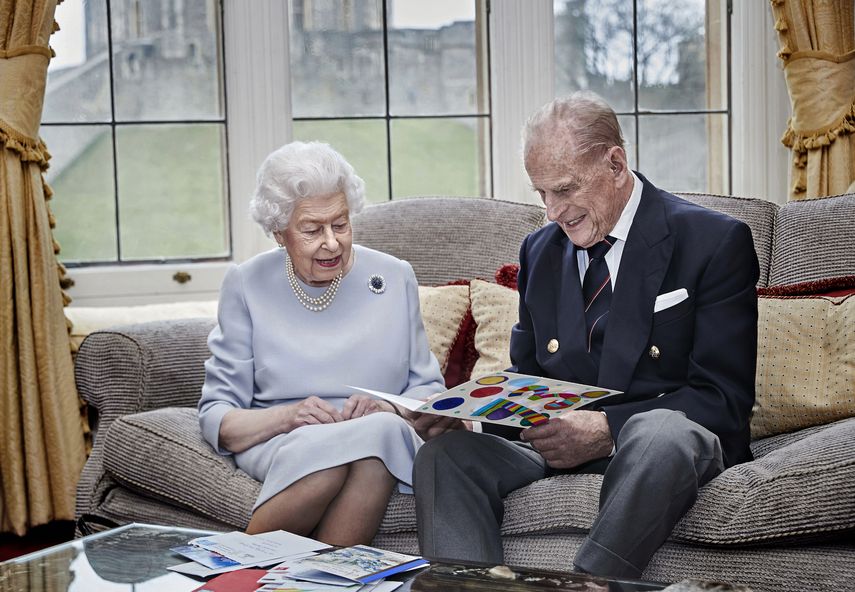 En esta imagen difundida el 19 de noviembre de 2020, la reina Isabel II y el príncipe Felipe leen una tarjeta de aniversario de parte de sus bisnietos, el príncipe Jorge, la princesa Carlota y el príncipe Luis, en el Castillo de Windsor, en Windsor, Inglaterra. Isabel y su esposo pasarán Navidad en el Castillo de Windsor en lugar de ir a su hacienda Sandringham por primera vez en décadas, dijeron voceros del Palacio de Buckingham el martes 1 de diciembre.