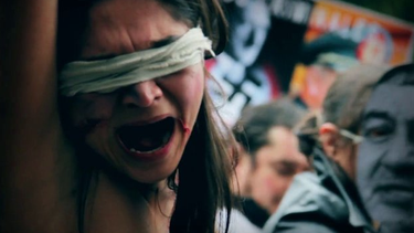 Una mujer representa durante una protesta, la tortura contra las mujeres en Chile. (Archivo La Cuna Films, Captura YouTube)