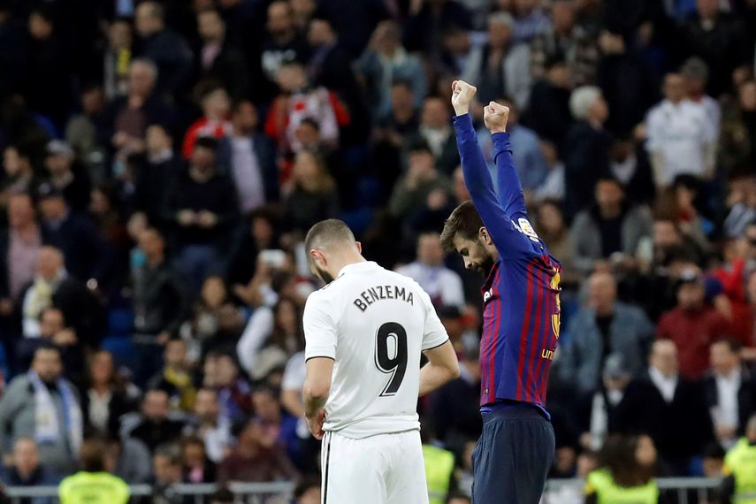 El defensa del FC Barcelona Gerard&nbsp;Piqué&nbsp;(d) celebra la victoria junto a Karim Benzema, del Real Madrid, tras el partido de la 26ª jornada de Liga en Primera División que Real Madrid y FC Barcelona jugaron esta noche en el estadio Santiago Bernabéu, en Madrid.&nbsp;