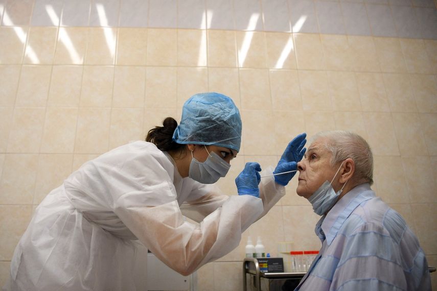 Un trabajador m&eacute;dico que usa equipo de protecci&oacute;n toma un hisopo de una mujer en un centro m&eacute;dico en Mosc&uacute; el 16 de julio de 2020, el primer d&iacute;a en que la capital rusa comenz&oacute; a proporcionar pruebas gratuitas de la enfermedad por coronavirus a sus residentes.