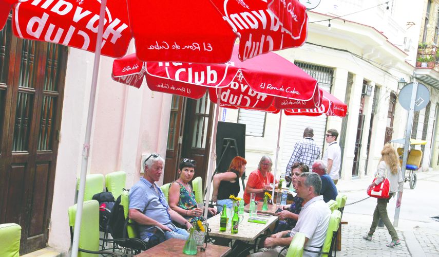 Tursitas extranjeros consumen cervezas en una terraza de la zona colonial de La Habana.