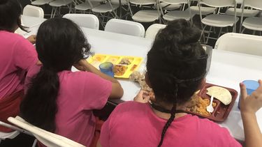 Fotografía fechada el 20 de junio de 2018, cedida por el Departamento de Salud y Servicios Sociales (HHS), que muestra a varios niños inmigrantes en el comedor del Refugio Temporal de Homestead para niños inmigrantes no acompañados, en&nbsp;Florida.&nbsp;