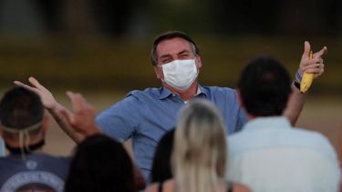 El presidente de Brasil, Jair Bolsonaro lleva mascarilla mientras habla con sus partidarios durante una ceremonia para retirar la bandera nacional en el exterior de su residencia oficial, en el Palacio Alvorada, en Brasilia.