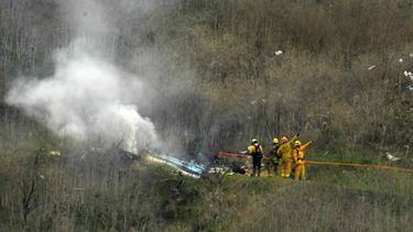 En esta foto del 26 de enero de 2020, los bomberos apagan restos del helic&oacute;ptero que se estrell&oacute; en la localidad de Calabasas, California, causando la muerte del exbasquetbolista Kobe Bryant y de otras ocho personas&nbsp;
