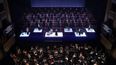 Escena de gran formato que reúne coro, solistas y orquesta en una propuesta escénica contemporánea.