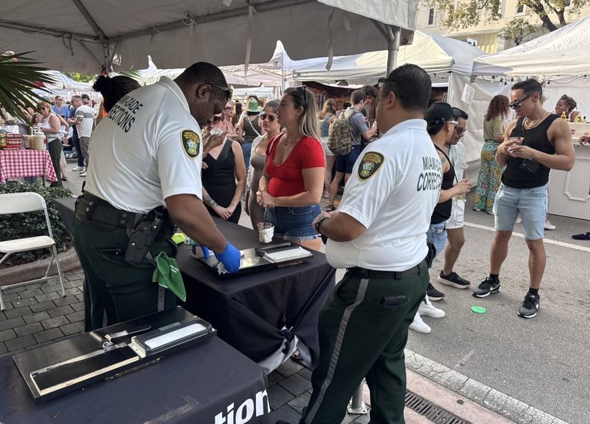 Agentes del Departamento de Correcciones de Miami-Dade conversan con asistentes durante la jornada. &nbsp;