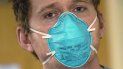 El enfermero Scott McGieson lleva una máscara N95 mientras sale de la habitación de un paciente en la unidad de cuidados intensivos del Centro Médico Harborview, el viernes 14 de enero de 2022, en Seattle. 