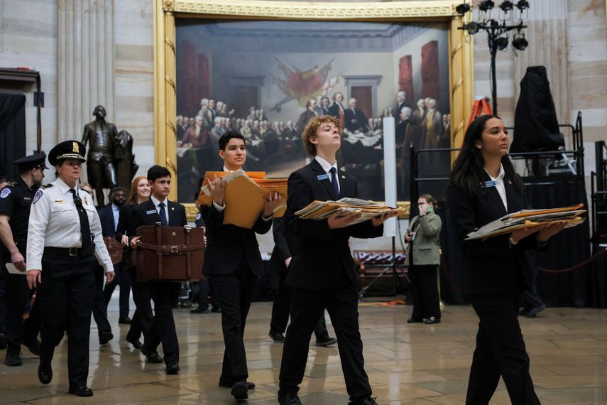 Jóvenes con los resultados por cada Estado se dirigen al pleno de la Cámara de Representantes para la ceremonia de certificación de los resultados electorales de noviembre de 2024.