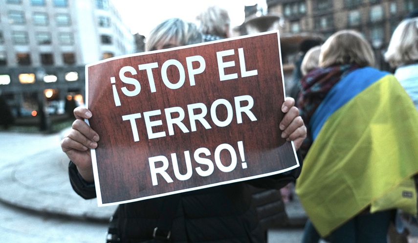 Una persona sostiene un cartel durante una manifestación en España contra la invasión.