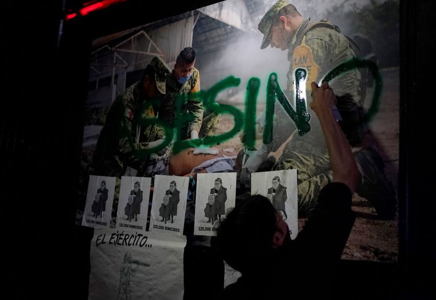 Un manifestante escribe la palabra Asesino con pintura en aerosol en una pared durante una marcha hacia el Senado para protestar contra la propuesta del presidente mexicano de trasladar a la Guardia Nacional al control operativo y administrativo de la Secretaría de Defensa, en la Ciudad de México, el martes 6 de septiembre de 2022.&nbsp;