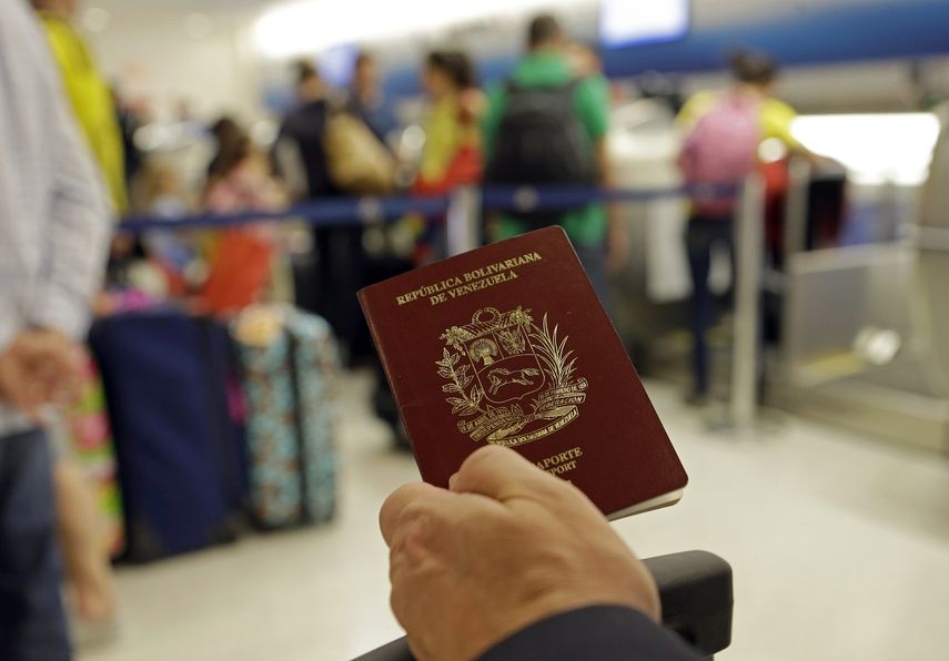 Fotografía de archivo de un hombre que muestra su pasaporte venezolano en el Aeropuerto Internacional de Miami, en junio de 2014.