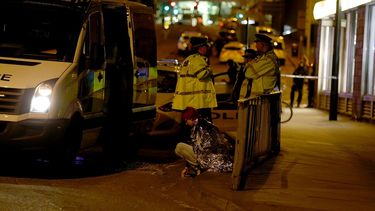Una mujer es vista sentada en una calle cercana al&nbsp;Manchester&nbsp;Arena, junto a un grupo de policías, luego de las dos explosiones registradas cerca al lugar donde se celebraba un concierto de la cantante Ariana Grande en&nbsp;Manchester, al norte de Inglaterra, este lunes 22 de mayo de 2017.&nbsp;