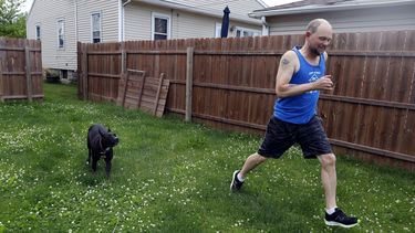 Christian Hainds juega con su perra Reyna en el patio de su casa en Hammond, Indiana, el 7 de junio de 2021.&nbsp;