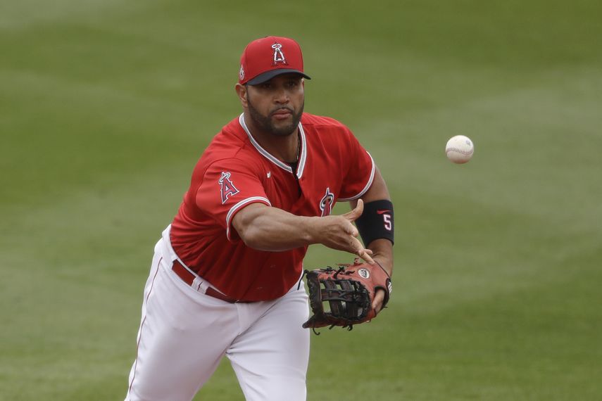 En esta foto de archivo del 28 de febrero de 2020, el dominicano Albert Pujols, de los Angelinos de Los &Aacute;ngeles, lanza una pelota en un juego de pretemporada ante los Rangers de Texas en Tempe, Arizona