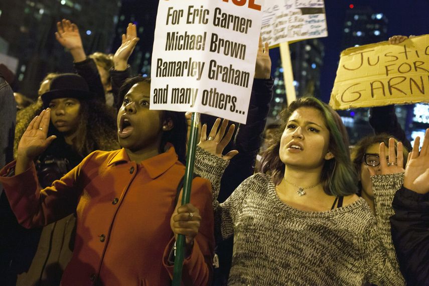 Vista de varias personas sosteniendo carteles de manifestación por la muerte de Eric Garner.&nbsp;