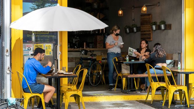Una empleada atiende a clientes en un restaurante.