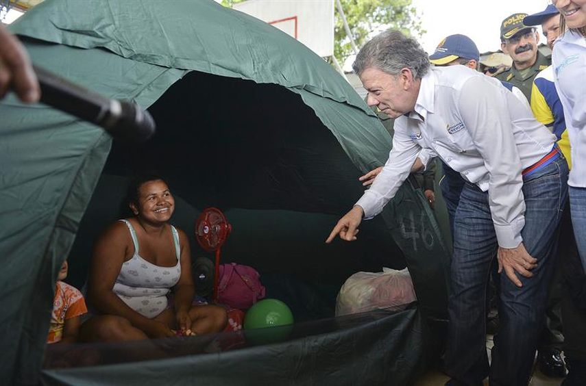 El presidente colombiano, Juan Manuel Santos, saluda a una mujer durante una visita a algunos albergues en Cúcuta, ciudad fronteriza con Venezuela. (EFE)