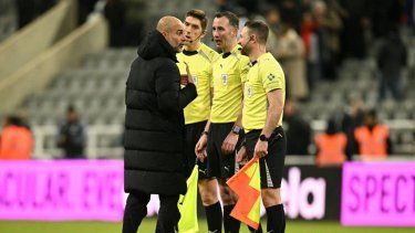 El entrenador español del Manchester City, Pep Guardiola (izq.), habla con el árbitro inglés Chris Kavanagh y sus asistentes después del partido de ida de la semifinal de la Copa de la Liga inglesa entre el Newcastle United y el Manchester City en St James Park en Newcastle