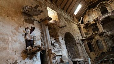 El pastor de alpacas Esteban Taipe, sube al púlpito de la iglesia abandonada del pueblo fantasma de Santa Bárbara, Perú, el jueves 2 de diciembre de 2021. Durante la época colonial española, Santa Bárbara fue la mina de mercurio más grande de América.