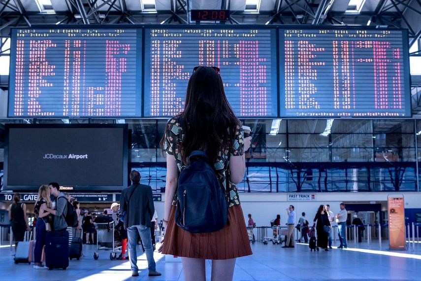 Una pasajera observa la pizarra de itinerarios de vuelo.