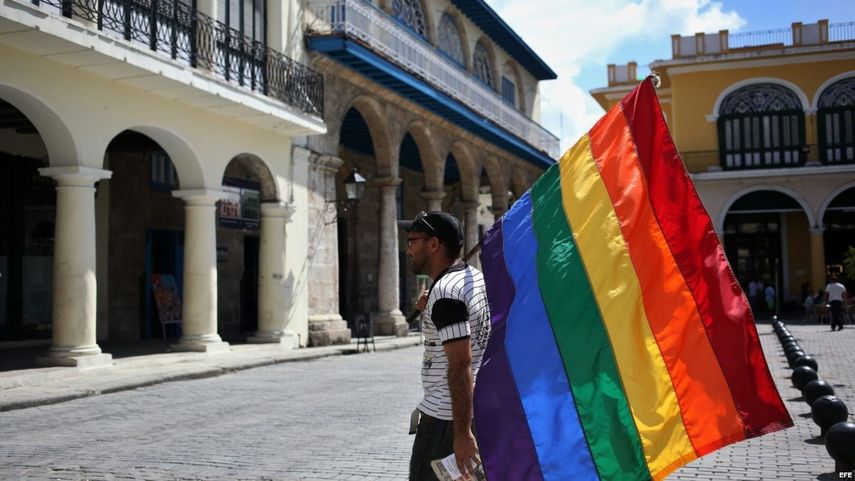 Un activista camina por una plaza de La Habana con una bandera del arco iris, símbolo de la comunidad gay.
