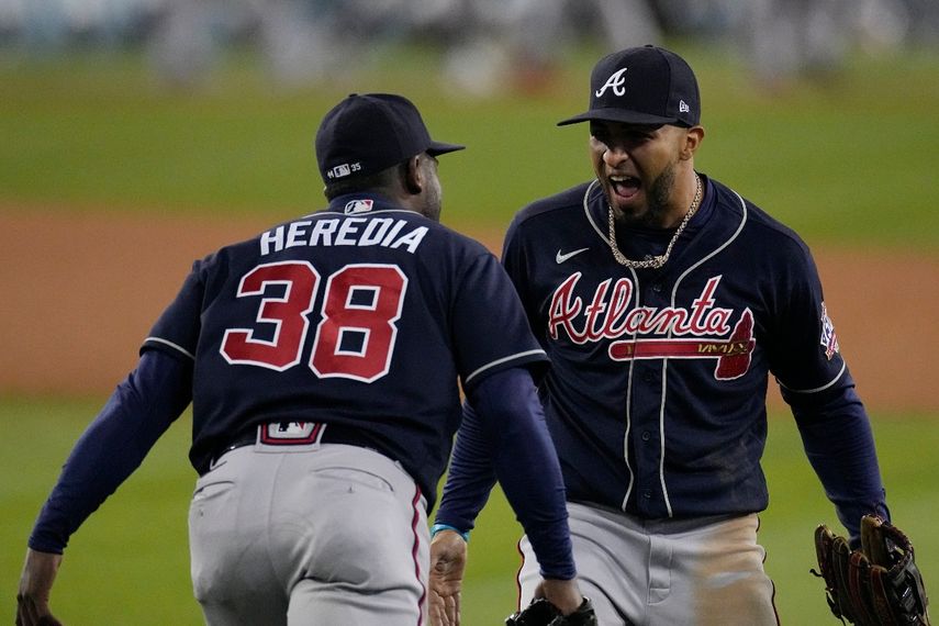 El puertorriqueño Eddie Rosario, jardinero izquierdo de los Bravos de Atlanta, festeja con su compañero, el cubano Guillermo Heredia, tras ganar el cuarto juego de la Serie de Campeonato de la Liga Nacional