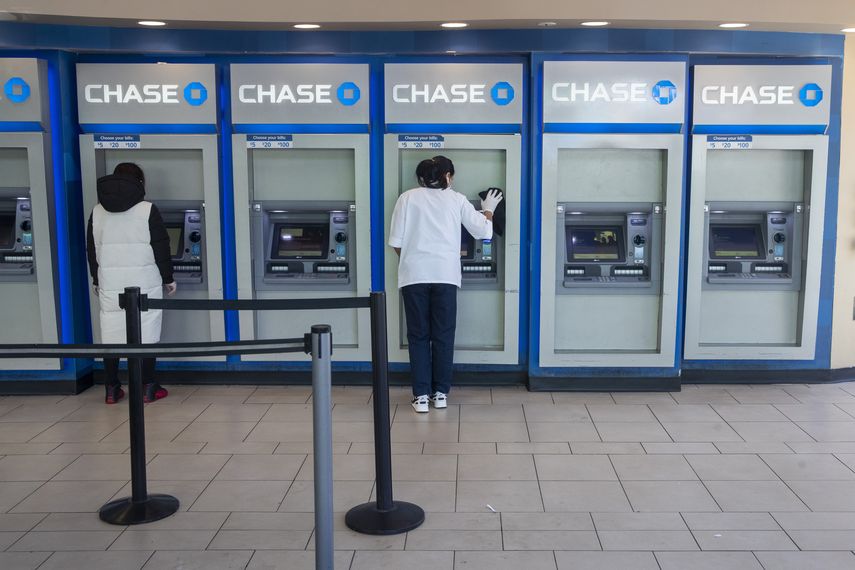 Una empleada del banco Chase desinfecta cajeros automáticos en una sucursal de Queens, Nueva York.  