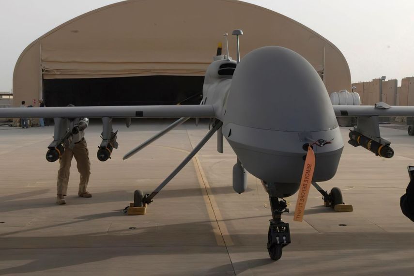 En esta imagen suministrada por el ejército de EEUU, contratistas de General Atomics montan un misil Hellfire en un MQ-1C Gray Eagle.