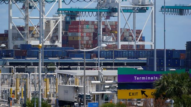 Contenedores de carga siendo acumulados por grúas en PortMiami, en Miami.
