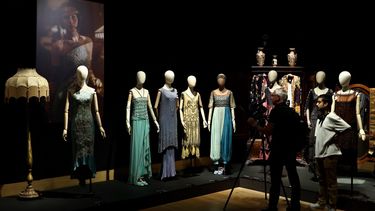Una persona filma una colección de vestidos pertenecientes a personajes de la serie de televisión y cine Downton Abbey, incluyendo el vestido de pavo real de Lady Edith y el vestido Criterion de Lady Mary, durante una vista previa de prensa para una exhibición de accesorios, vestuario y otros artículos de la franquicia antes de su subasta, en el centro de Londres el 8 de agosto de 2025.&nbsp;
