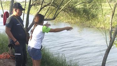 En esta imagen del domingo 23 de junio de 2019, Tania Vanessa Ávalos, de El Salvador, habla con las autoridades mexicanas después de que su esposo y su hija, de casi dos años de edad, fueran arrastrados por la corriente mientras intentaban cruzar el Río Bravo desde Matamoros, México, hacia Brownsville, Texas.