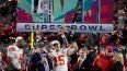 El quarterback de los Chiefs de Kansas City, Patrick Mahomes, sostiene el trofeo Vince Lombardi mientras habla con Terry Bradshaw tras ganar el Super Bowl 57, el domingo 12 de febrero del 2023.