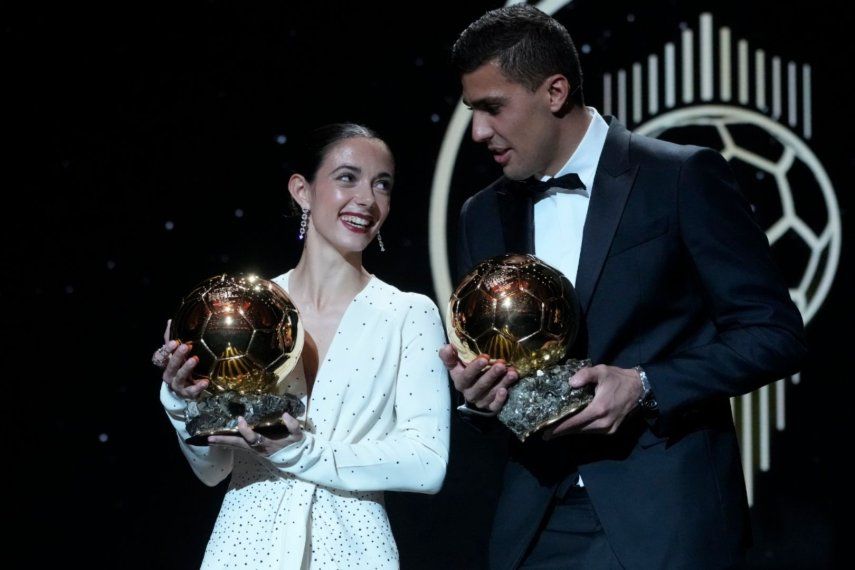 Los jugadores españoles Aitana Bonmatí (izquierda) y Rodri Hernández muestras sus trofeos al Balón de Oro, el lunes 28 de octubre de 2024, en París.