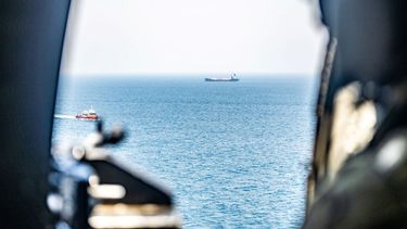 Un helicóptero del Ejército de EEUU observa el tránsito de buques comerciales mientras sobrevuela aguas regionales cerca del Estrecho de Ormuz durante el operativo de bloqueo marítimo contra Irán.