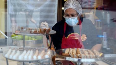 Una trabajadora usa una mascarilla mientras prepara postres en el Universal City Walk, el viernes 14 de mayo de 2021 en Universal City, California