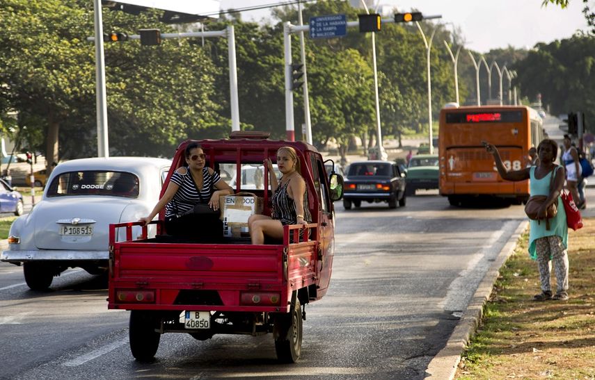 Dos mujeres viajan en la parte trasera de una camioneta por una de las privilegiadas calles de La Habana, Cuba, el jueves 27 de junio de 2019.
