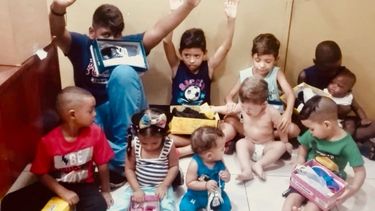Dari&eacute;n, al centro y con mono azul, recibe junto a otro ni&ntilde;os regalos de navidad en un albergue de C&aacute;ritas Panam&aacute;.&nbsp;J.A.G. Tob&oacute;n