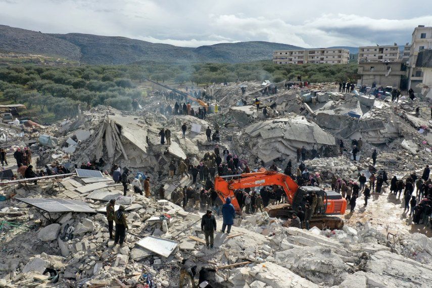 Esta vista aérea muestra a los residentes que buscan víctimas y sobrevivientes entre los escombros de los edificios derrumbados luego de un terremoto en la aldea de Besnia cerca del pueblo de Harim, en la provincia noroccidental de Idlib en Siria, controlada por los rebeldes, en la frontera con Turquía, el 6 de febrero de 2022.&nbsp;&nbsp;