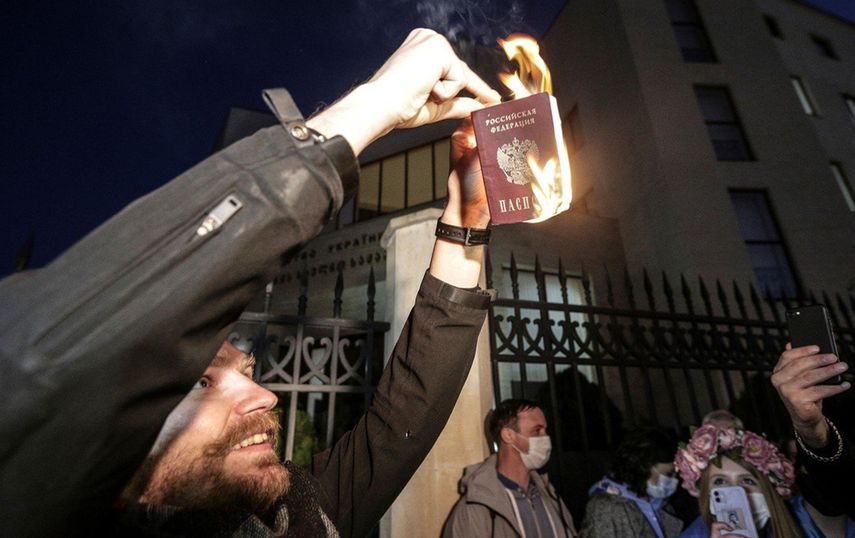 Un hombre quema un pasaporte ruso en protesta a la invasión de su país a Ucrania en Tbilisi, Georgia.