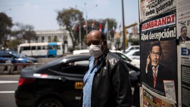 Un hombre usando mascarilla para protegerse del nuevo coronavirus pasa junto a un puesto de periódicos que muestra en primera plana al presidente Martín Vizcarra, afuera del Congreso en Lima, Perú, el viernes 11 de septiembre de 2020. 
