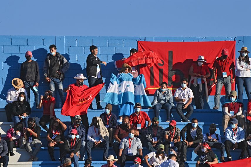 Los partidarios de la presidenta electa de Honduras, Xiomara Castro, esperan a que comience su ceremonia de toma de posesión, junto a un cartel que la representa, en Tegucigalpa, el 27 de enero de 2022